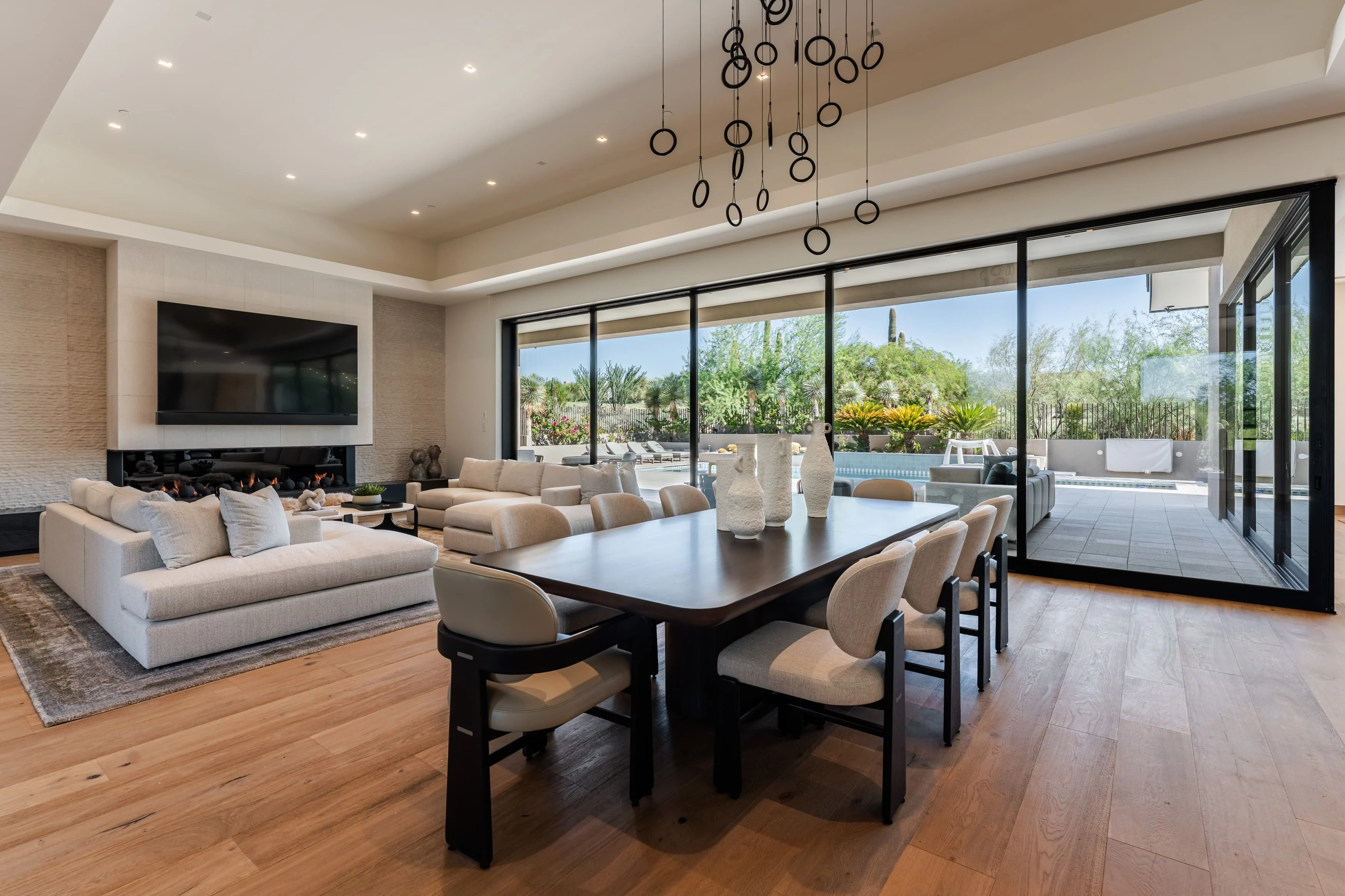 Phoenix Interior Design Living and dining room by Phoenix Interior Design LLC opening onto a pool terrace in Scottsdale, Arizona